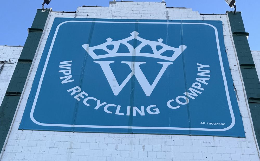 Close view of the teal WPN Recycling Company crown sign on the building.